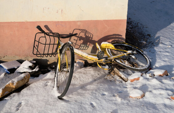 Bike sharing abandoned in the corner after the snow