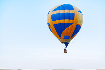 Multicolored air balloon in clear blue sky