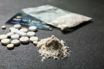 Cocaine and pills on dark background