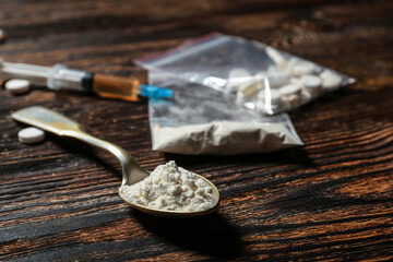 Spoon with drugs on wooden background