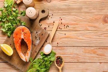 Raw salmon steak, spices and herbs on wooden background