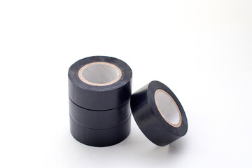 Stack of rolls black vinyl insulating tape on the white background.