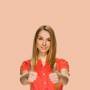 Young attarctive smiling girl showing two thumbs up