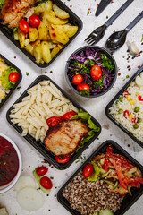 Lunch boxes: dishes in disposable plastic dishes, Russian cuisine - borsch, soup, rice, vegetables, pasta, meat cutlets, mushrooms. Top view
