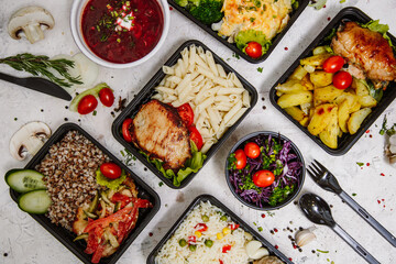 Lunch boxes: dishes in disposable plastic dishes, Russian cuisine - borsch, soup, rice, vegetables, pasta, meat cutlets, mushrooms. Top view