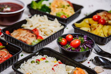 Lunch boxes: dishes in disposable plastic dishes, Russian cuisine - borsch, soup, rice, vegetables, pasta, meat cutlets, mushrooms. Top view
