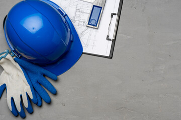 Hardhat, gloves and blueprints of a builder