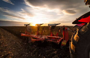 Tractor on the field during sunset.