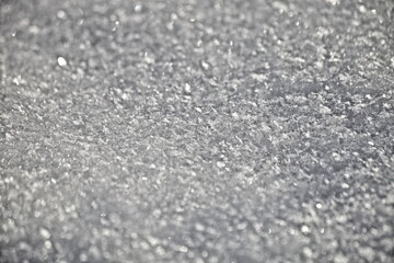 White snow crystals texture background with snowflakes closeup