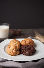 Cookies on a wooden table with a glass of milk and wheat ear