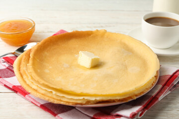 Concept of tasty breakfast with thin pancakes on white wooden table