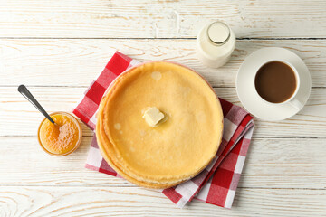 Concept of tasty breakfast with thin pancakes on white wooden table