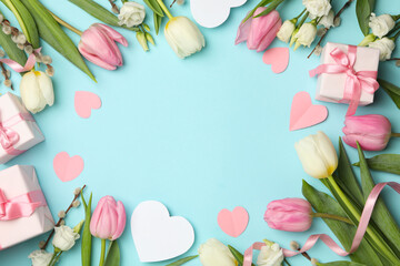 8 march concept with different flowers and gift boxes on blue background, space for text