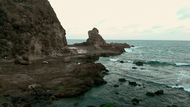 Landscape view of rock cliff at tropical beach with Indian Ocean background