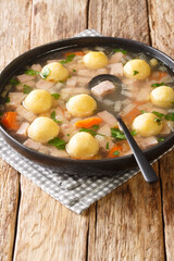 Liechtenstein Ham Soup And Cornmeal Dumplings closeup in the plate on the table. vertical