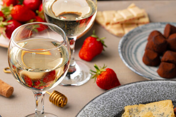 Glass of white wine, truffel chocolates and strawberry close up