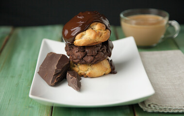 Melted chocolate pouring on cookies with pieces of chocolate and coffee latte