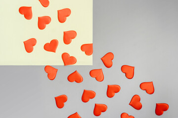 Red hearts fly from yellow square to gray background. Copy space. Flat lay. Valentines day concept.