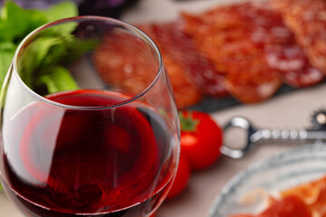 Meat slicing and wine on gray background