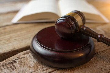 Court and justice. Judge's hammer on a wooden table against the background of books, constitution