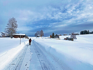 Hikers and walkers on the beautiful idyllic fresh snow of the Churfirsten mountain range and in the...