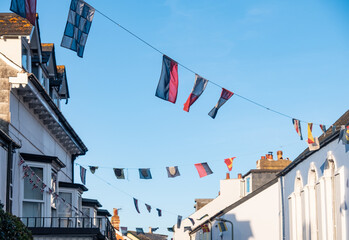 Fototapeta na wymiar Regatta flags flying from the rooftops in Shaldon, Devon for the historic regatta week in the summer.