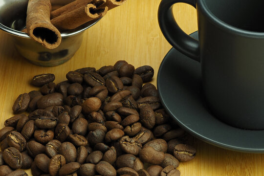 Coffee beans with a cup of coffee and a cinnamon