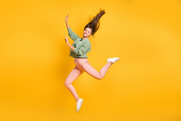 Fototapeta na wymiar Full size photo of young happy positive good mood cheerful girl jumping with flying hair isolated on yellow color background