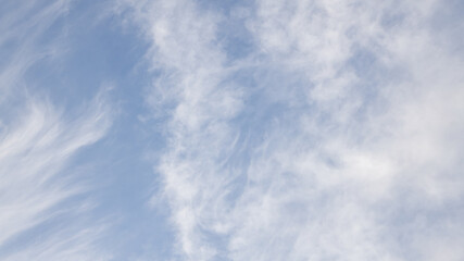 High white cirrus clouds with cirro-stratus in a light blue sky, sometimes called chair tails, indicate nice weather, but stormy changes come within a few days. White clouds in a blue sky. 