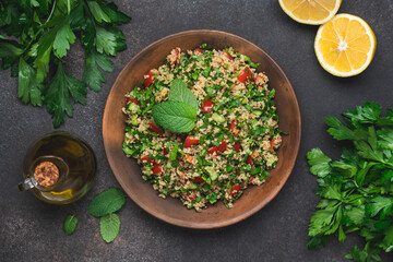 Obraz na płótnie Canvas Quinoa salad with parsley, cucumber and cherry tomatoes. Tabbouleh Traditional middle eastern or arab dish