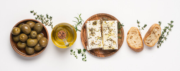 Olives and soft salted cheese feta with herbs on white background. Mediterranean traditional food