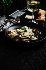 Ravioli with spinach, ricotta and parmesan on a black plate