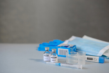 vials of coronavirus vaccine, medical supplies on a blue surface, covid-19 vaccination, medical concept