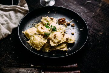 Ravioli with spinach, ricotta and parmesan on a black plate