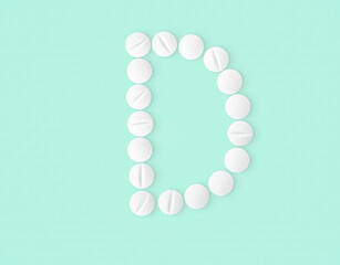 letter D made of vitamin pills