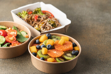 Cooked food in paper eco-friendly containers. Food delivery for home or office. Vegetable, fruit salads and noodles 