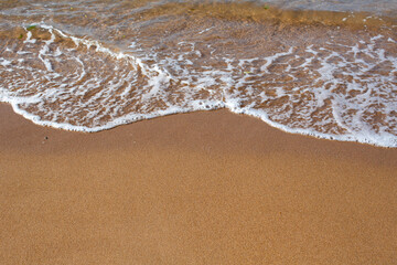 Sand on the beach with a sea wave