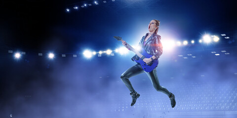 Fototapeta na wymiar Young and beautiful rock girl playing the electric guitar
