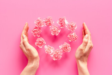 Heart shape of flowers with hands. Valentines Day, wedding or birthday greeting card, top view