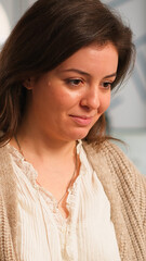 Close up of authentic happy professional employee sending mails sitting at desk in front of lapotop smiling, working financial startup company. Diverse team analyzes statistics data in modern office