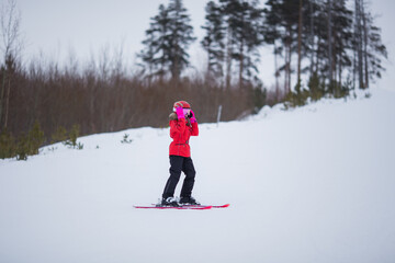 Active adorable preschooler caucasian girl portrait with ski in helmet, goggles and bright suit enjoy winter extreme sport activities. Child skiing in mountains