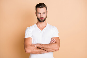 Photo of young handsome business man serious confident crossed hands boss isolated over beige color...