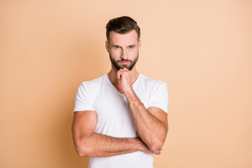 Photo of young handsome man think ponder pensive serious hand touch chin isolated over beige color...