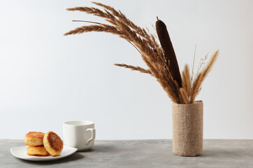 A few pancakes on a white plate and an empty mug