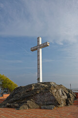 The metal cross Monument of the headland of the small Coastal Town of Almunica, on a late bright afternoon in September.