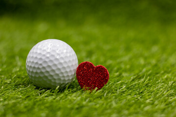 Golf ball for Valentine's Day on green grass with love