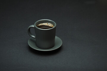 Coffee cup with a grey saucer on a black background