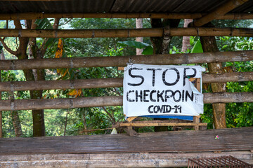 Stop Checkpoint Covid-19 rustic sign banner on wooden stand. South Asia anti covid measures. Travel ban in Philippines. Stop banner template. Covid checkpoint in rustic village. Virus pandemic action