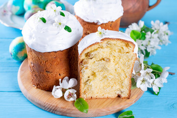 Traditional easter cake kulich Ukrainian Russian style with colored eggs on blue background