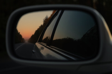 Fototapeta na wymiar Sunset in the rearview mirror of the car